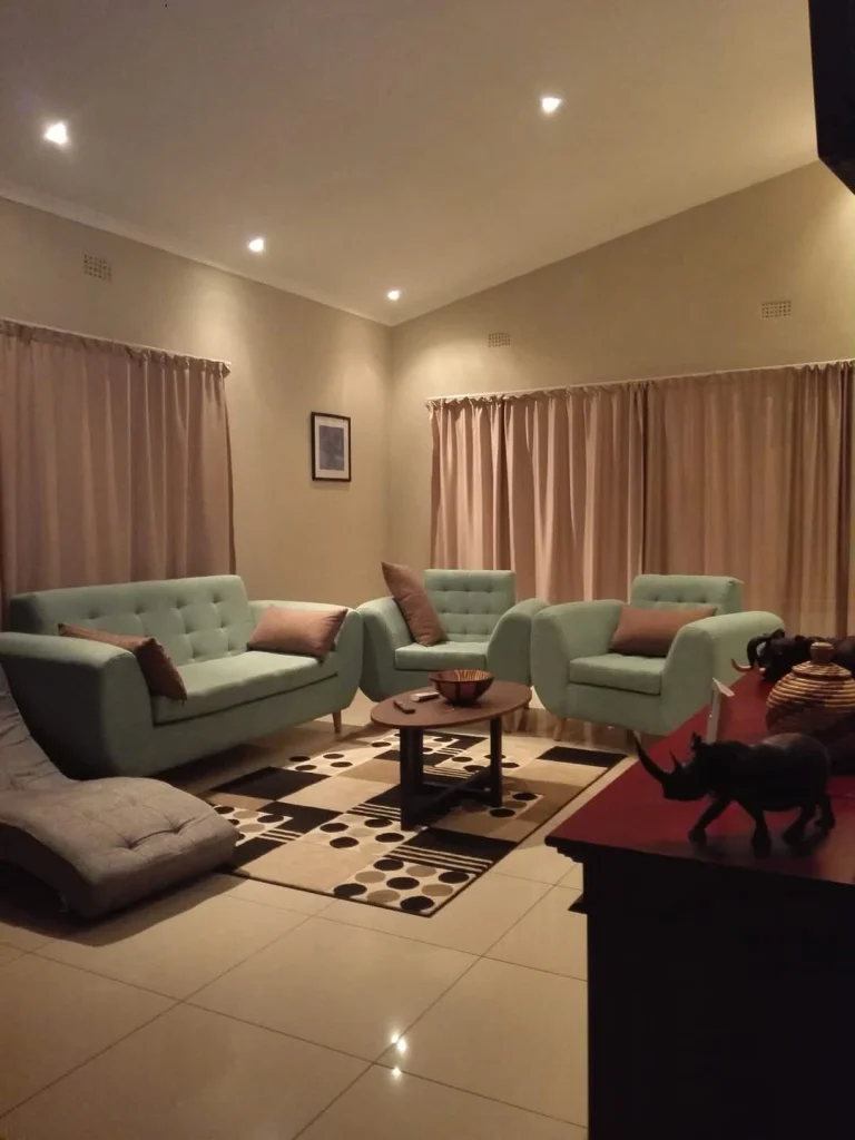 “Luxury family double room exterior at Chobe Sunset Chalets with shaded outdoor seating.”